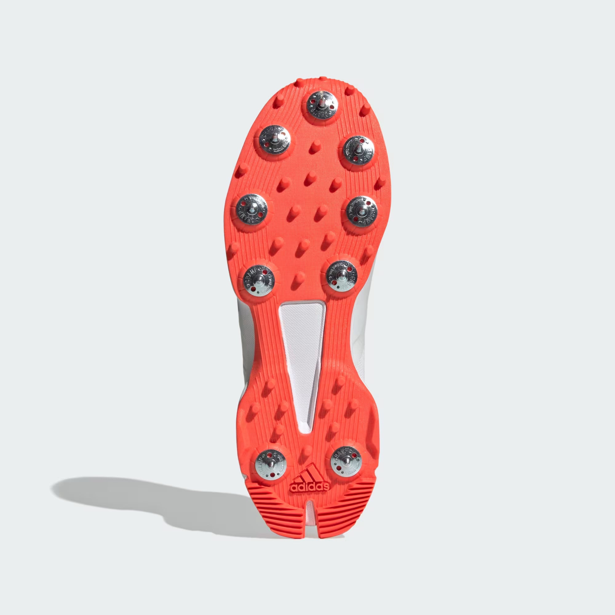 Red soccer cleat sole with metal studs on a white background