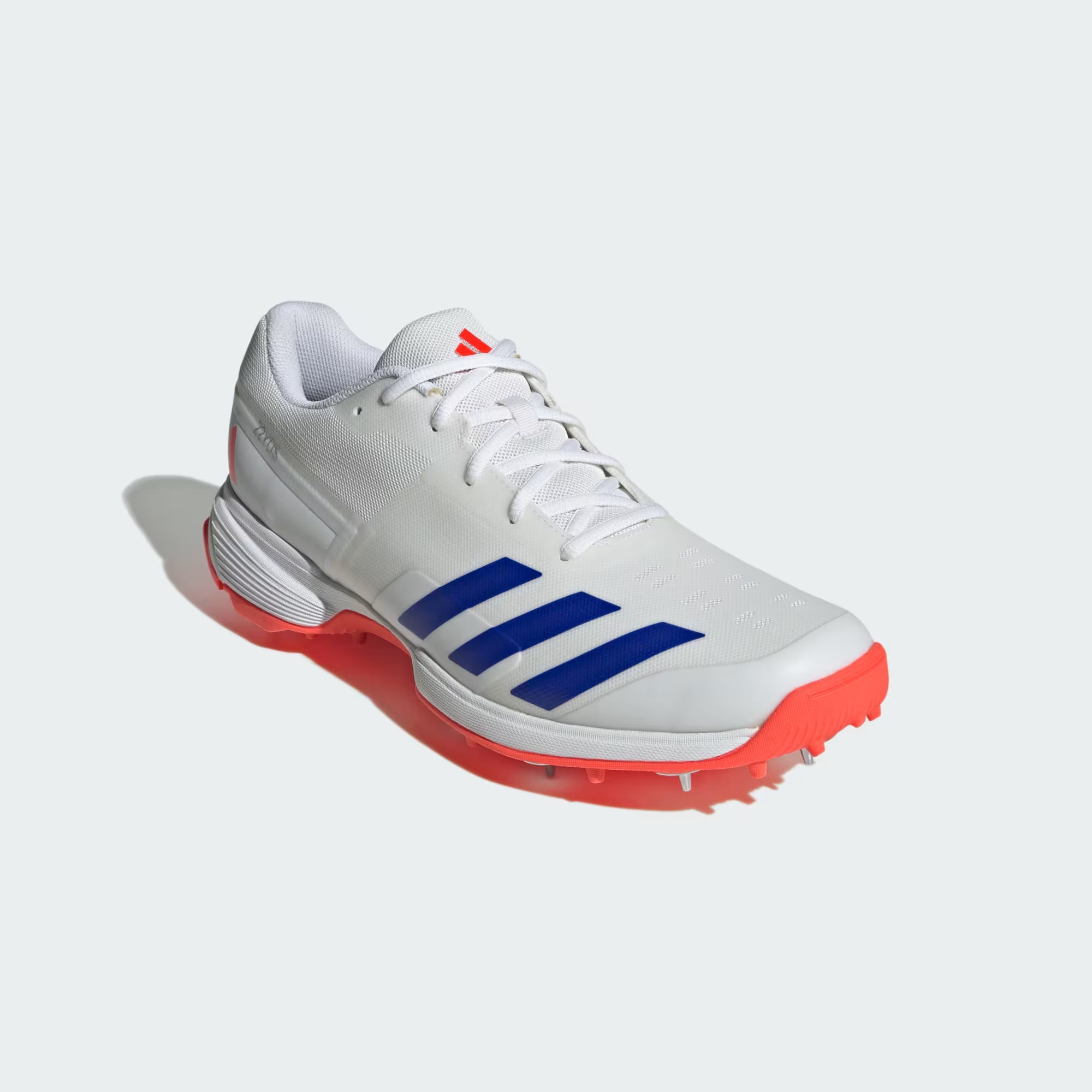 White athletic shoe with blue stripes and red soles on a white background