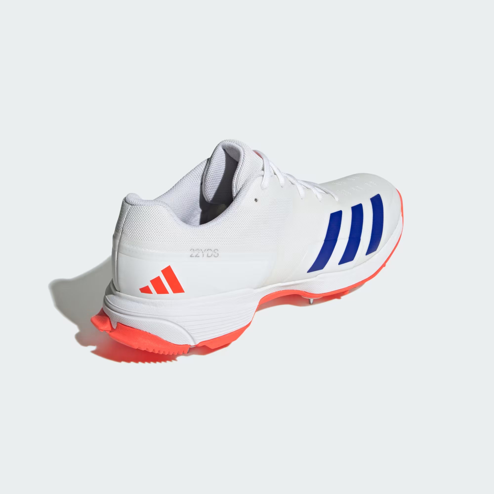 White athletic shoe with blue stripes and red soles on a white background