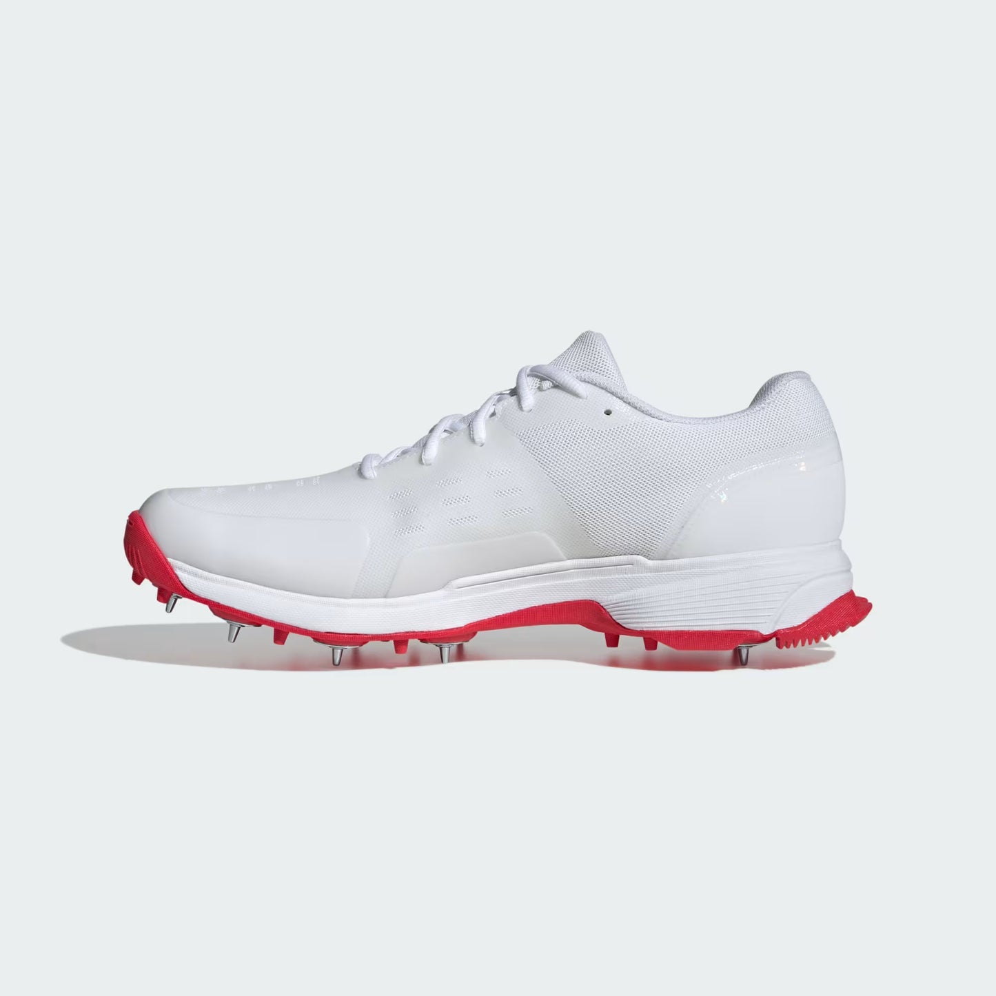 White golf shoe with red cleats on a white background