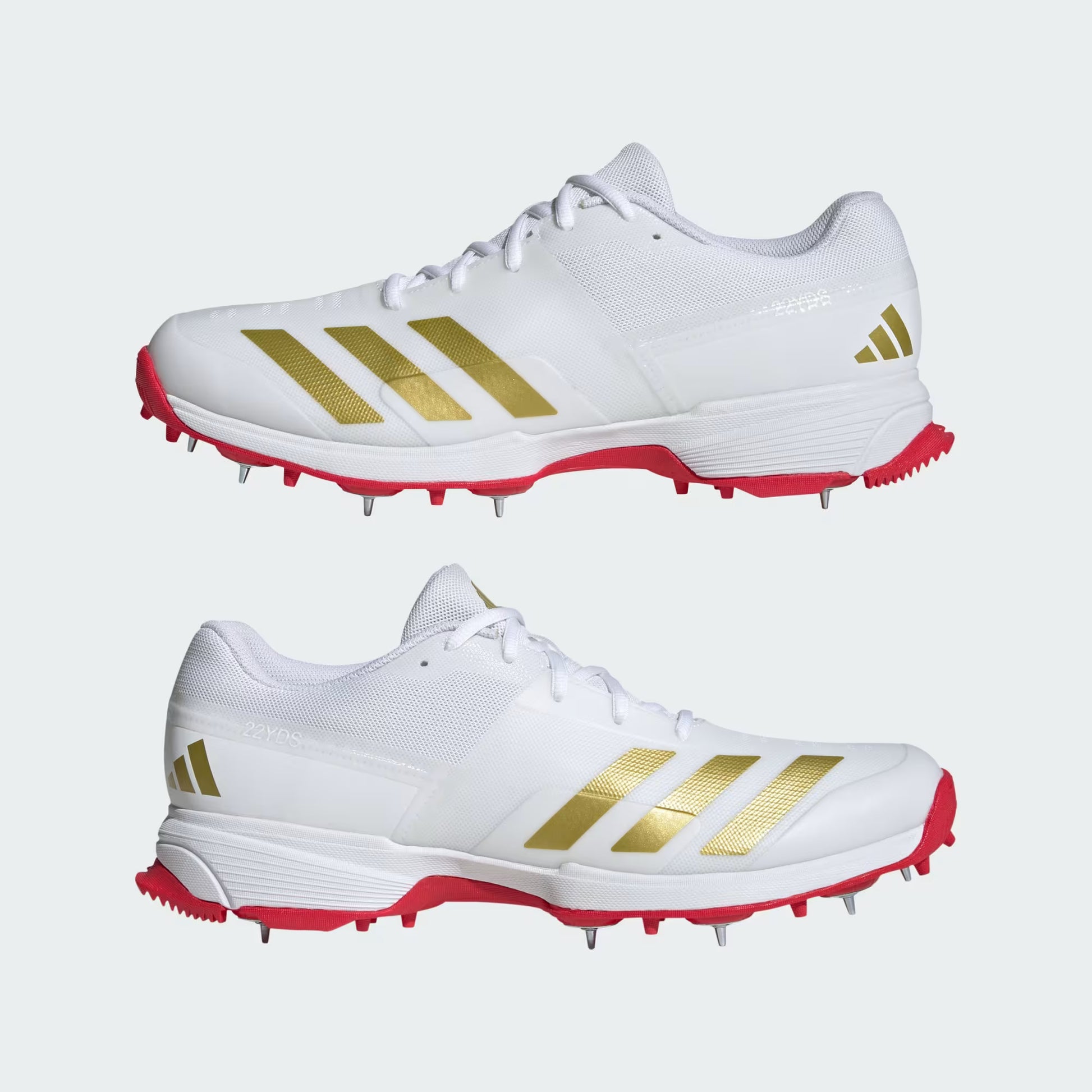 White sports shoes with gold stripes and red soles on a white background