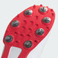 Close-up of a red soccer cleat sole with tread pattern on a white background
