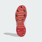 Red soccer cleat sole with gold studs on a white background