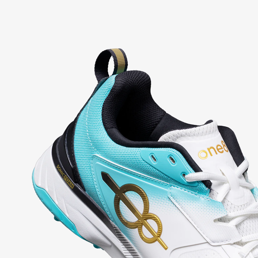 Side view of teal gradient cricket spike shoes with padded heel and grip sole